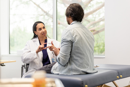 a doctor using sign language to communicate with her patient